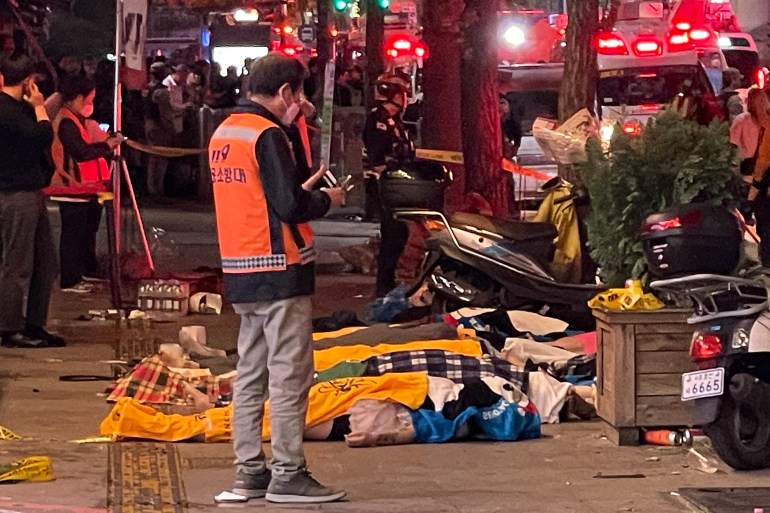 The bodies of victims, believed to be in cardiac arrest, are covered with blankets in the popular Itaewon nightlife district in Seoul on October 30, 2022.