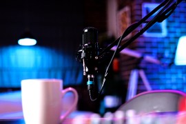 A coffee cup sits next to a mic in a recording studio at a radio station