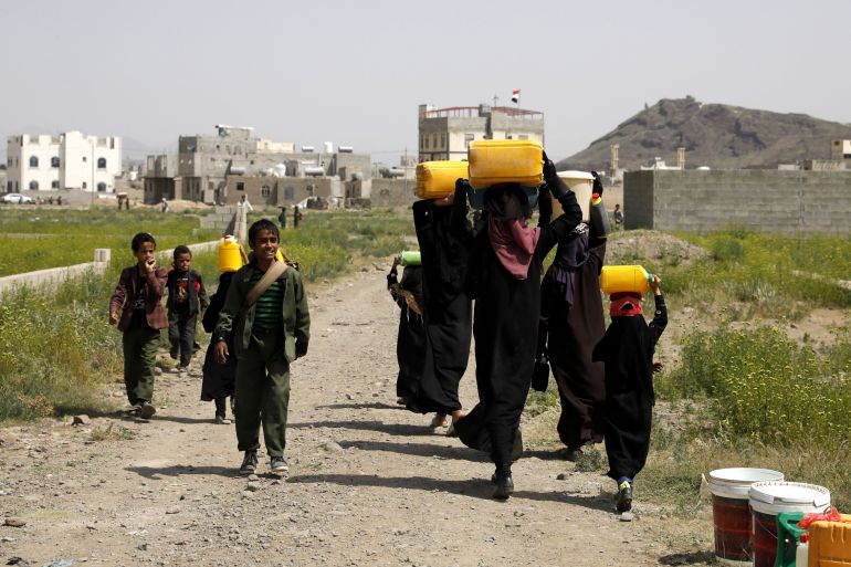 Yemeni boys pass women carrying water jerrycans on their heads after filling them from a donated tank on the outskirts of Sana'a, Yemen, 14 September 2022. Over 17 million people lack access to safe water and adequate sanitation services in war-ravaged Yemen, according to UN estimates. The Arab country is one of the most water-scarce countries in the world. EPA-EFE/YAHYA ARHAB