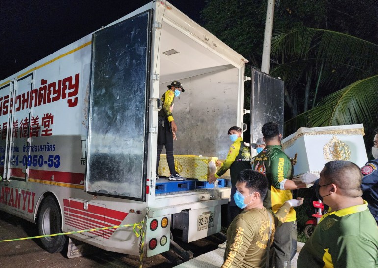 Rescue workers loading into a truck the coffins containing the mass shooting victims at a childcare center in Nong Bua Lamphu province, northeastern Thailand