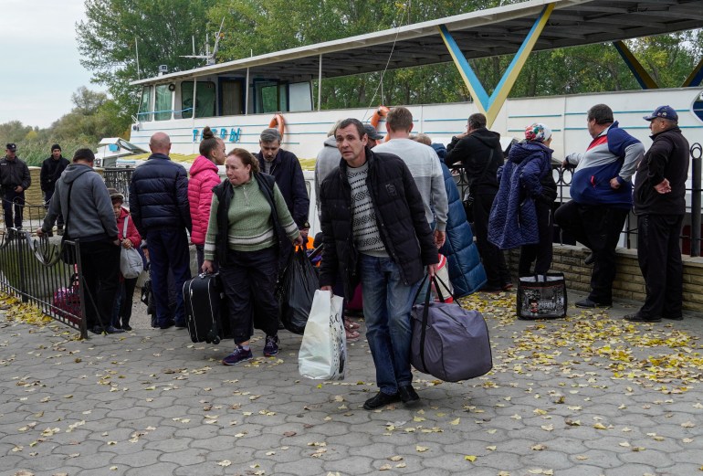 Kherson residents evacuated from Kherson carry luggage after their arrival to Oleshky, Kherson region, Ukraine