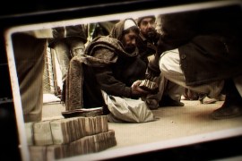A photo of an Afghan man holding money