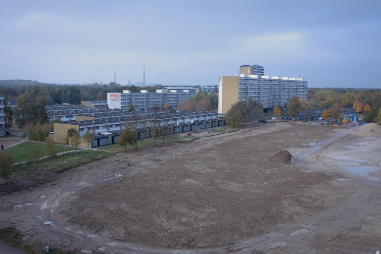 A large sand pit was left where a 13-story building was demolished in the Vollsmose neighborhood as part of Denmark's policies targeting the so-called 