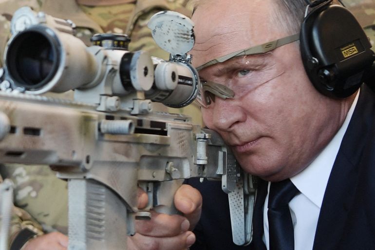 Russian President Vladimir Putin looks through the scope as he shoots a Chukavin sniper rifle (SVC-380) during a visit to the military Patriot Park in Kubinka, outside Moscow, in September 2018 [File: Alexey Nilkolsky/Sputnik/ AFP]