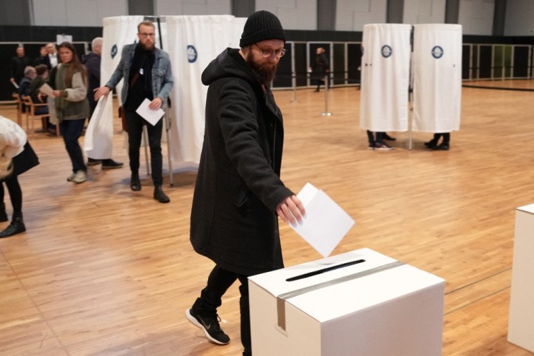 A voter casts a ballot for the general election at a polling station in Aalborghallen