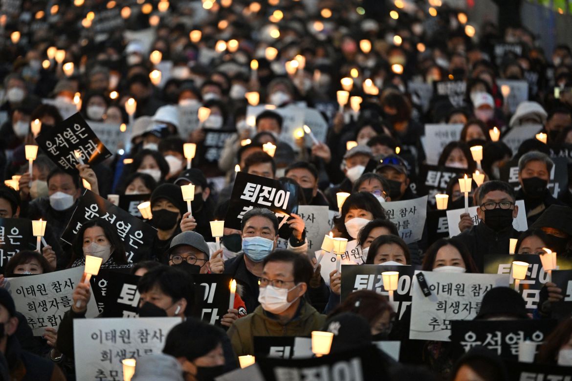 People take part in a candlelight vigil to commemorate the 156 people killed on October 29.