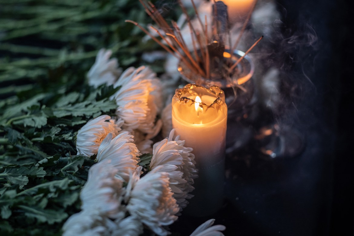 Chrysanthemums and candles are displayed at an incense altar during a candlelight vigil in Jeju to commemorate the 156 people killed Halloween crowd crush.