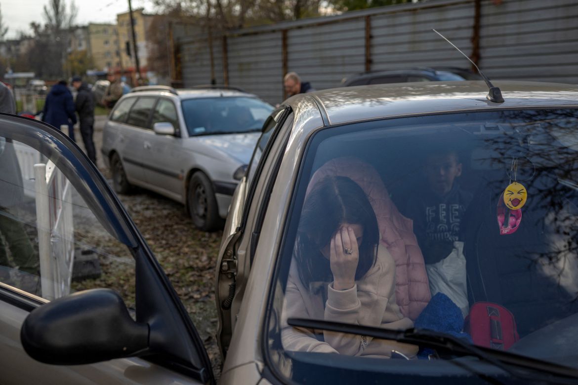 A Ukranian woman sits in a car with her family .