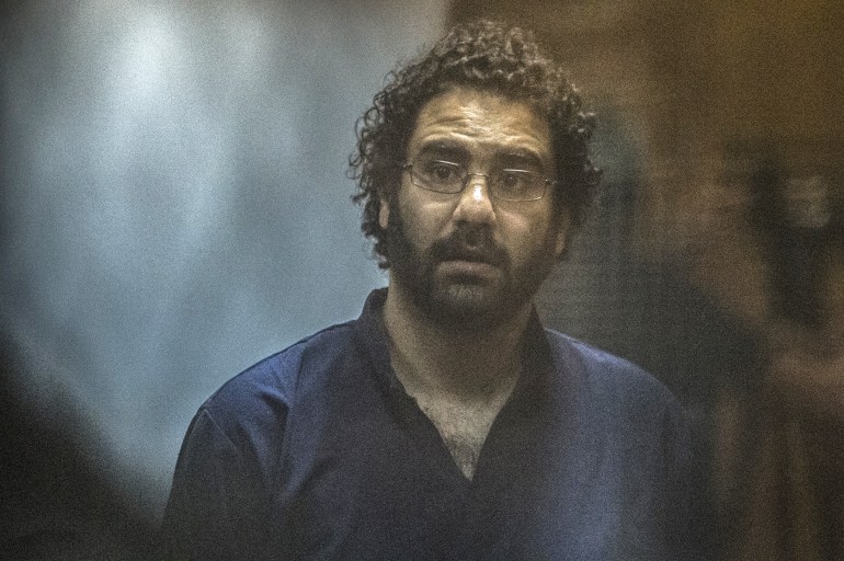 In this file photo taken on May 23, 2015, Egyptian activist and blogger Alaa Abdel Fattah looks on from behind the defendant's cage during his trial for insulting the judiciary, in the capital Cairo.