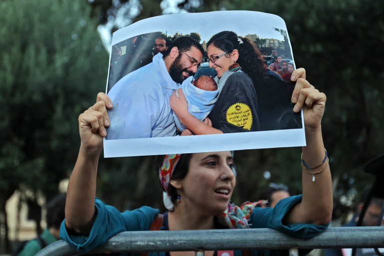 Protester holding up photo of imprisoned Egyptian activist Alaa Abd el-Fattah and his family