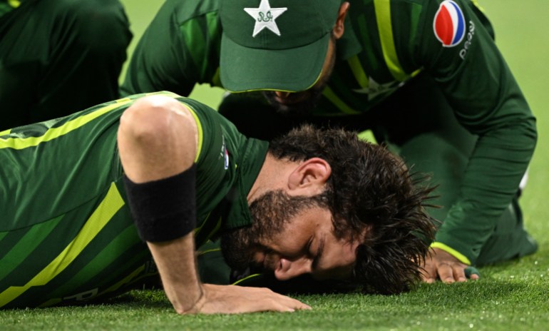 Pakistan's Shaheen Shah Afridi (C) reacts with teammates after injury while taking a catch to dismiss England's Harry Brook