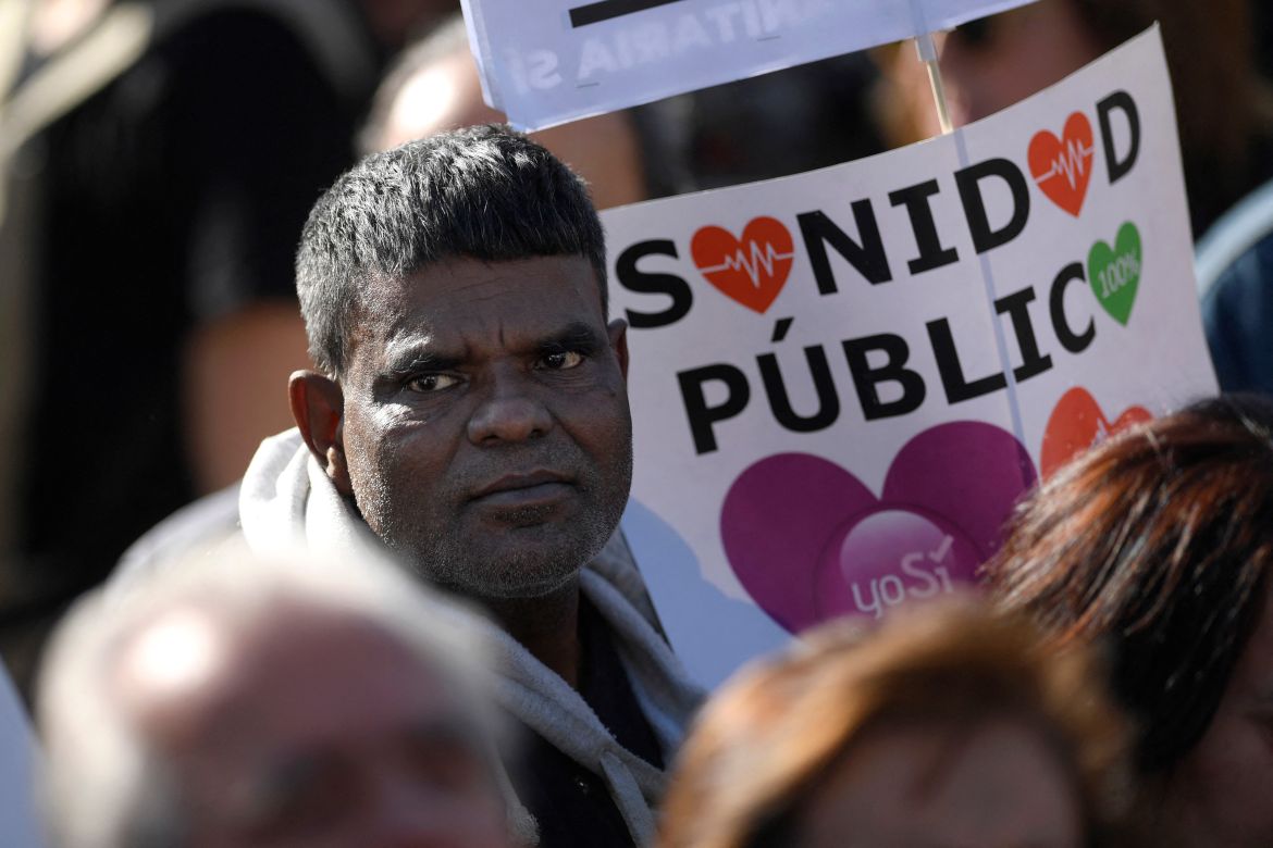 A protester holds a sign supporting the public healthcare during a demonstration called by citizens under the slogan