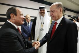 Turkish President Recep Tayyip Erdogan (R) shakes hands with Egyptian President Abdel Fattah el-Sisi at the 2022 FIFA World Cup in Doha, Qatar