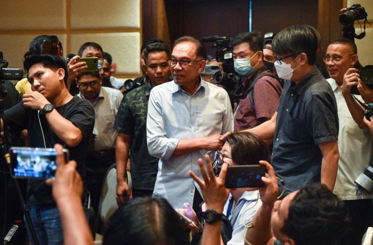 Anwar Ibrahim participa de uma coletiva de imprensa onde muitos membros da mídia se reuniram.  ele parece serio