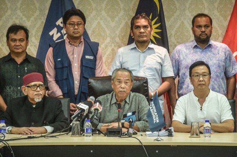Muhyiddin looking serious, flanked by the leaders of other parties in his coalition including PAS's Abdul Hadi Awang