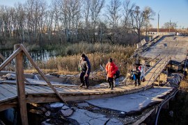 People walk on a damaged bridge in the town of Vovchansk, in Ukraine&#39;s northeastern Kharkiv region, on November 1 [File: Sergiy Kozlov/EPA-EFE]