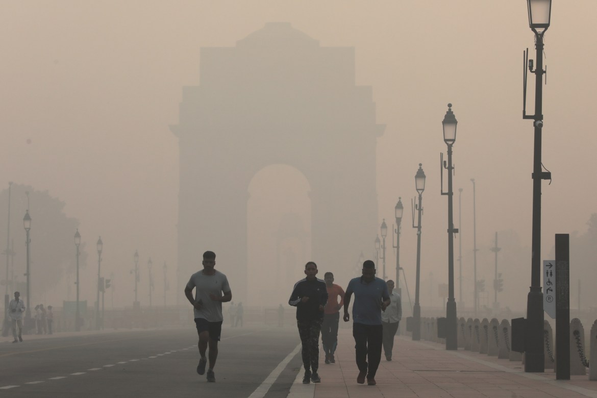 People jog as the city is engulfed in heavy smog at Rajpath, in New Delhi.