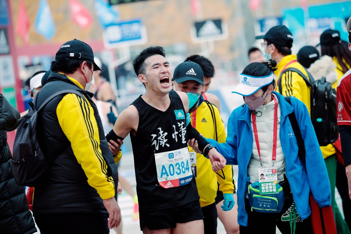 Medical volunteers assist a participant at the ending point of the Beijing Marathon