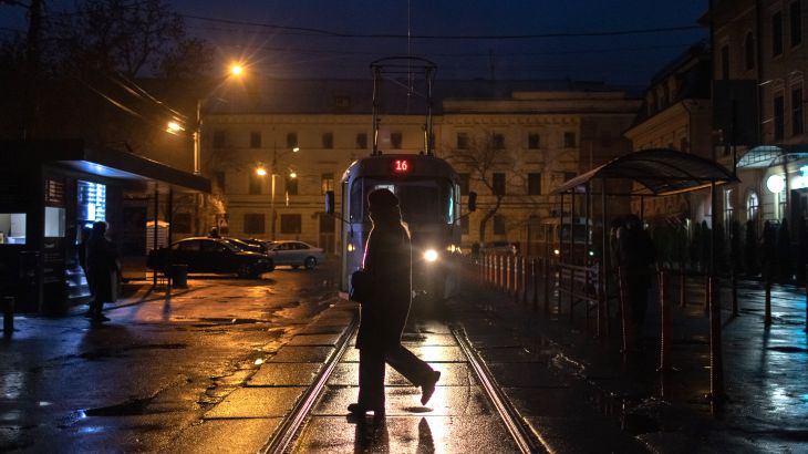 A person crosses a road as blackouts continue in downtown Kyiv