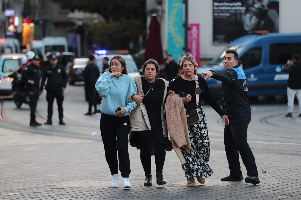 People run away as Turkish policemen try to secure the area after an explosion at Istiklal Street, in Istanbul.