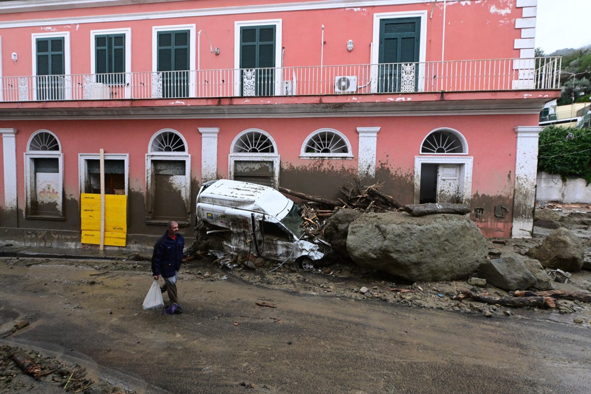 A man walks past damage caused by the landslide in Ischia island