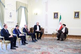 Iranian President Ebrahim Raisi, right, sits with a Russian delegation