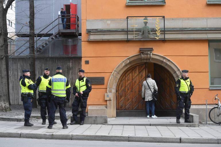 Police officers stand outside the Stockholm District Court