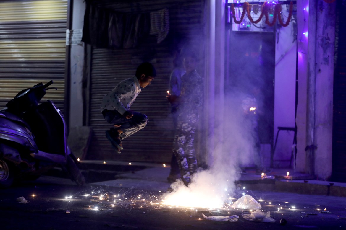 People watch as firecrackers burn during Diwali.