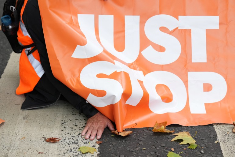 A 'Just Stop Oil' protester blocks a road leading into Westminster, in London on October 5