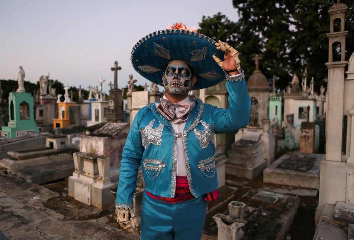 A man dressed up as a Mariachi and with his face painted as a skull