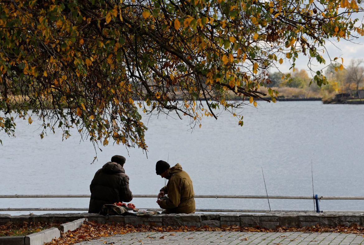 Men fish from the embankment, in the city of Kherson