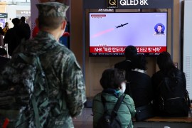 People in Seoul watch a TV broadcasting a news report on North Korea firing three ballistic missiles into the sea.