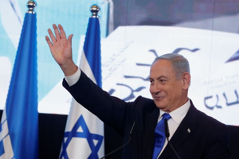 Benjamin Netanyahu waves as he addresses his supporters at his party headquarters