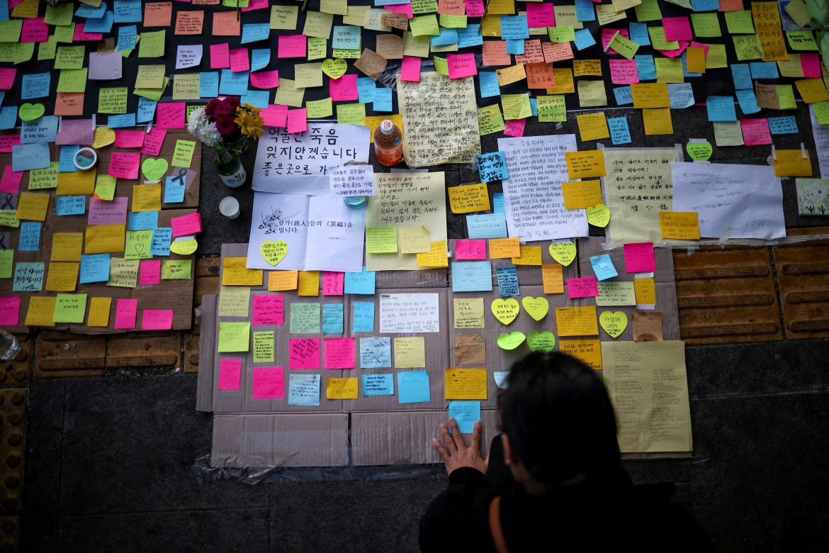 A mourner leaves a message near the site of a crowd crush.