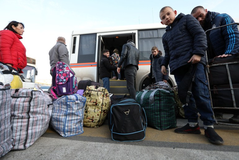 Civilians evacuated from the Russian-controlled Kherson region of Ukraine get off a bus as they arrive at a local railway station, after Russian-installed officials extended an evacuation order to the area along the eastern bank of the Dnipro River, in the town of Dzhankoi, Crimea November 2, 2022.