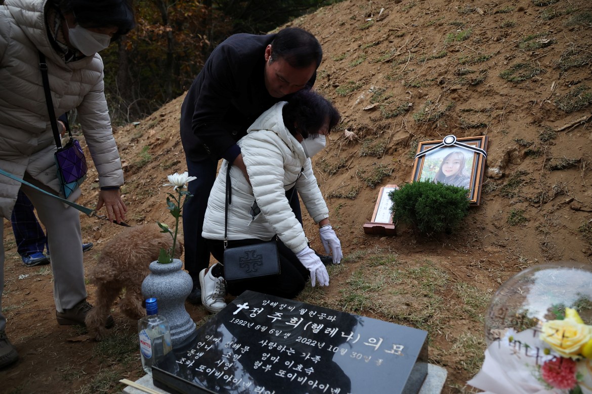 Mother grieves next to her daughter's grave