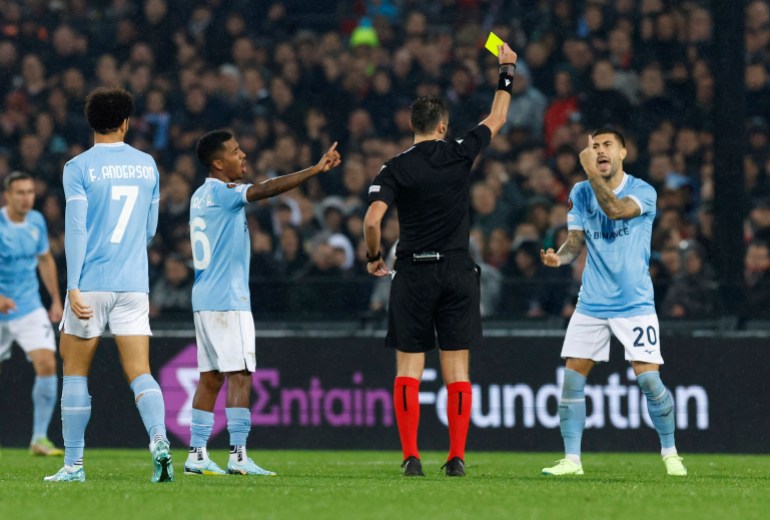 Lazio's Mattia Zaccagni is shown a yellow card