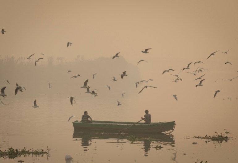 A man rows his boat in the Yamuna river amidst heavy smog in the old quarters of Delhi, India November 4, 2022