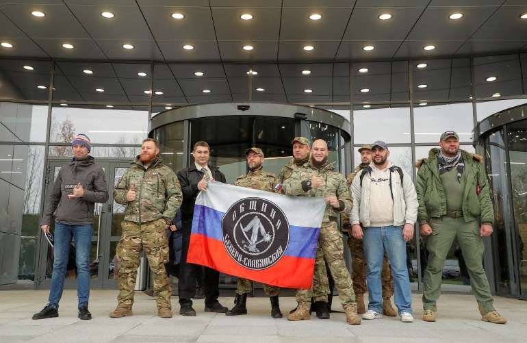 Ziyaretçiler, Wagner özel askeri grubu işadamı ve kurucusu Yevgeny Prigozhin tarafından 4 Kasım 2022'de Rusya'nın Saint Petersburg kentindeki ofis bloğunun resmi açılışı sırasında uygulanan bir proje olan PMC Wagner Center'ın önünde fotoğraf çektirmek için poz veriyor.