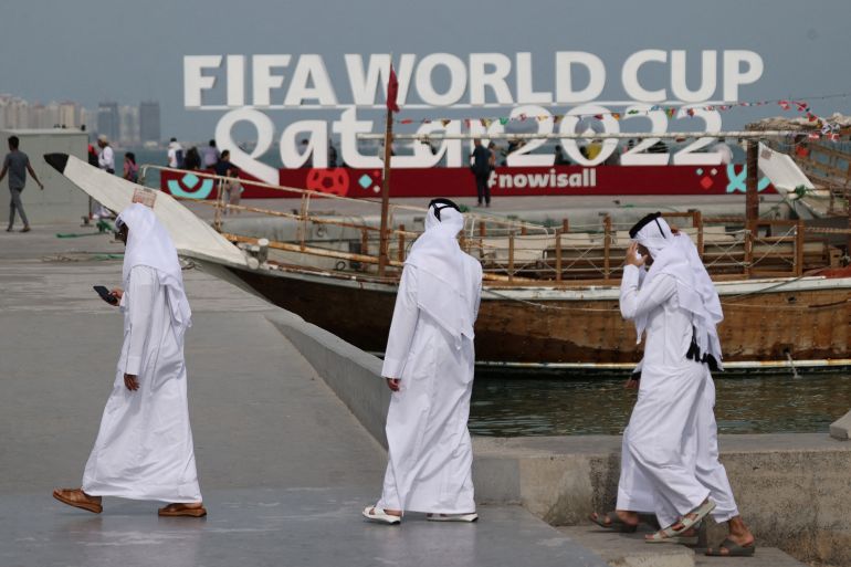 3 men near a large fifa world cup sign