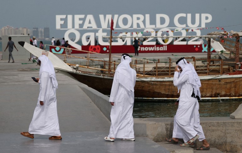 3 men near a large fifa world cup sign