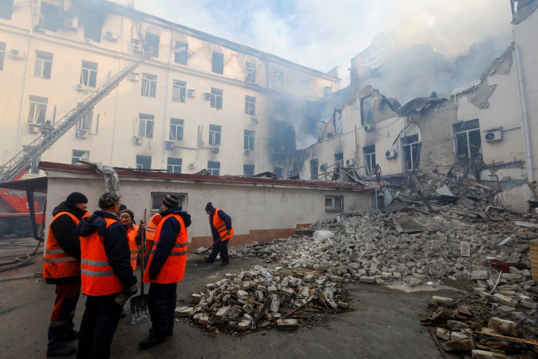 Municipal workers remove debris outside a local railway administration headquarters damaged in shelling in the course of Russia-Ukraine conflict in Donetsk