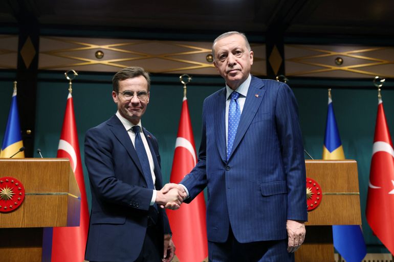 Turkish President Recep Tayyip Erdogan and Swedish Prime Minister Ulf Kristersson shake hands.