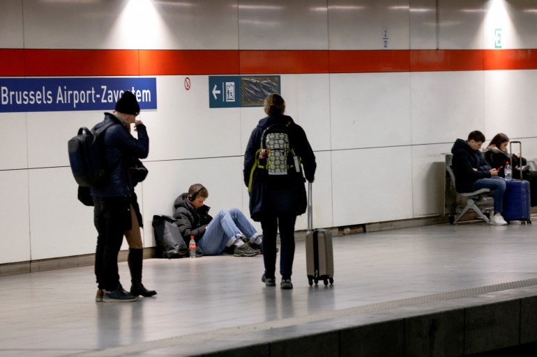 Passengers wait for one of the few trains at the Brussels Airport train station during a national strike, in Zaventem near Brussels, Belgium