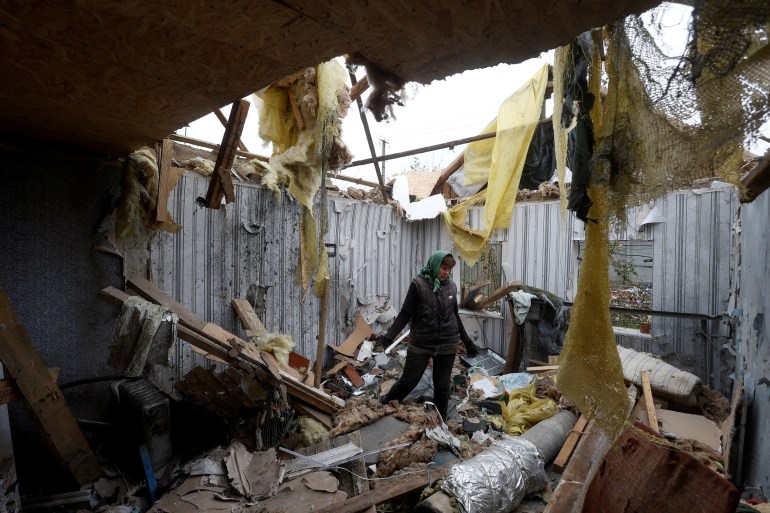 Local resident Serhii Tamara removes debris inside a house of her son, destroyed during a Russian military attack in the village of Novooleksandrivka, in Kherson region, Ukraine November 9