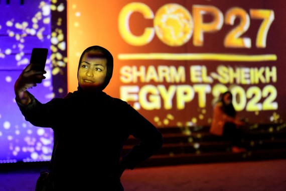 FILE PHOTO: A woman takes a selfie in front of a wall lit with the sign of COP27, as the COP27 climate summit takes place, at the Green Zone in Sharm el-Sheikh, Egypt November 10, 2022. REUTERS/Mohamed Abd El Ghany/File Photo
