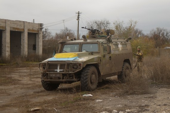 A Ukrainian service member stands next to a previously captured Russian armoured personnel carried in the village of Blahodatne, in Ukraine's Kherson region
