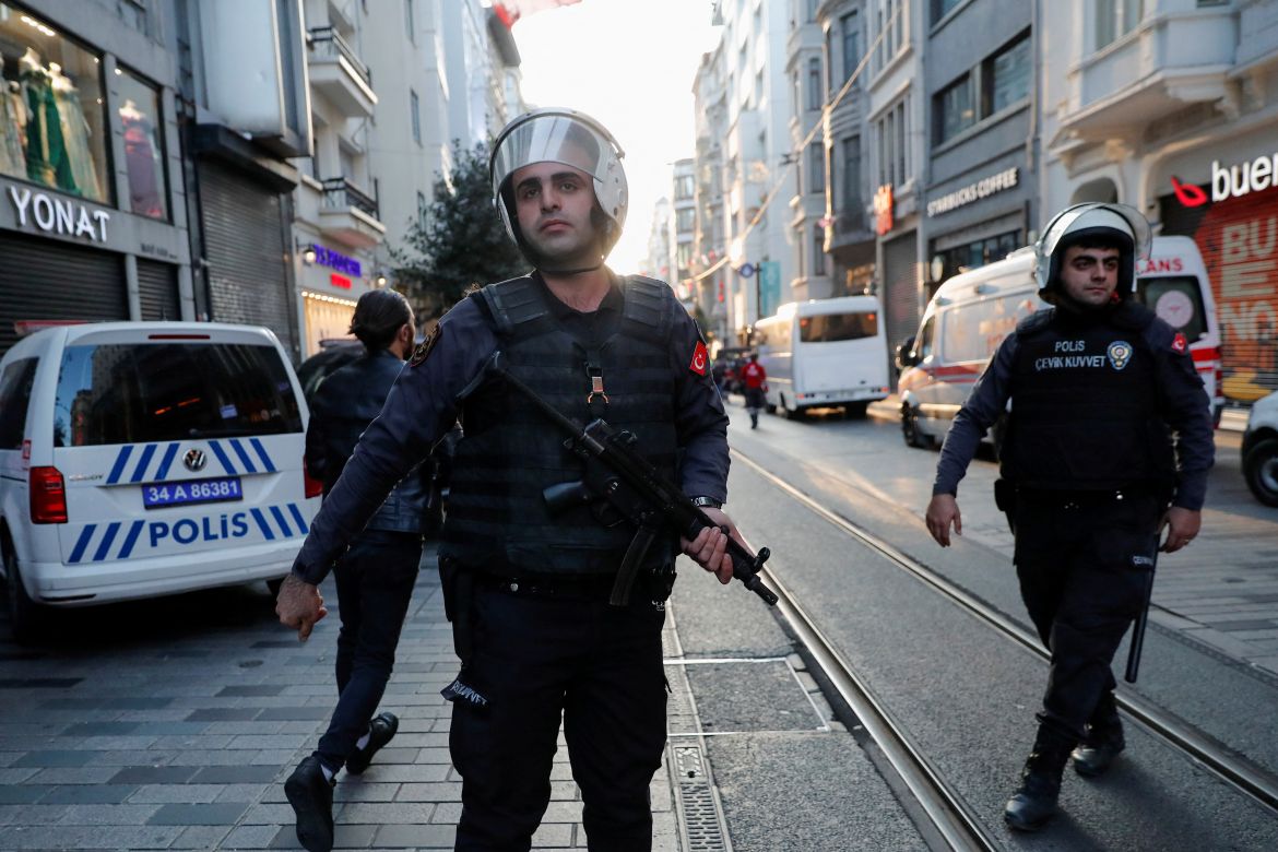 Police officers stand near the scene after an explosion on busy pedestrian Istiklal street in Istanbul.