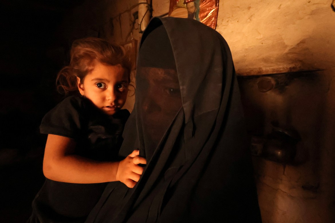 Hikma Meteab, 48, and her daughter Ghufran Abbas, 3, pose for a photograph at their family home in the village of Al-Bu Hussain, Iraq