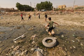 Children play ball games on the dried up riverbed of the Shatt al Mashkhab river